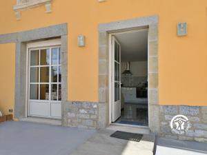 two doors of a house with a kitchen in the background at La Maison du Bourg, 4 personnes in Louverné
