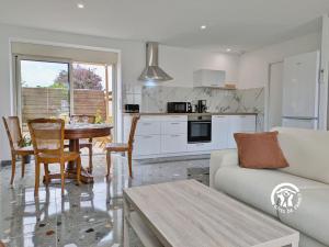 a living room with a couch and a table at La Maison du Bourg, 4 personnes in Louverné +14 photos