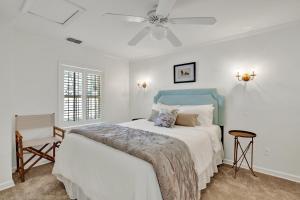 una camera da letto bianca con un letto e un ventilatore a soffitto di Elsewhere on Madison Square Carriage House a Savannah Altre 45 foto