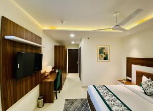 a hotel room with a bed and a flat screen tv at Hotel White Amritsar - A Luxury stay near golden temple in Amritsar