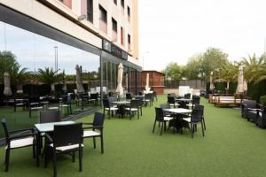 a restaurant with tables and chairs on a patio at Sercotel Las Artes Pinto in Pinto