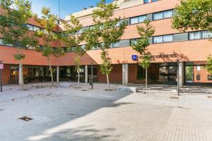 a large brick building with trees in front of it at Sercotel de los Reyes in San Sebastián de los Reyes