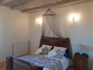 Saint-CybardeauxにあるChambre vue sur jardinの天蓋付きベッドのある寝室