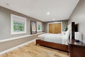 a bedroom with a bed and a desk and two windows at Chasing the Slopes in North Woodstock