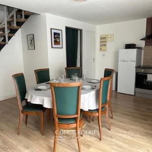 ein Esszimmer mit einem Tisch und Stühlen sowie eine Küche in der Unterkunft Évasion à Hainneville in Cherbourg en Cotentin
