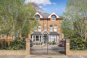 een stenen huis met een smeedijzeren hek bij Exceptional Luxury w Leisure Facilities in Teddington