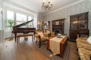 een woonkamer met een piano en een bank bij Exceptional Luxury w Leisure Facilities in Teddington