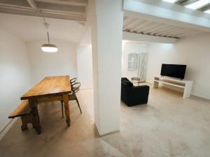 een woonkamer met een houten tafel en een televisie bij Sassoverde 9 in Arezzo