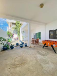 une pièce avec une table de ping-pong et des plantes en pot dans l'établissement Villa Fidjrossè, Cotonou, à Cotonou