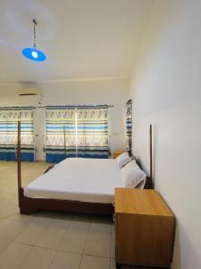 - une chambre avec un grand lit et des fenêtres dans l'établissement Villa Fidjrossè, Cotonou, à Cotonou