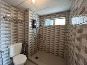 a bathroom with a toilet and a shower with a window at ALR Homestay Mvv in Port Dickson +3 photos