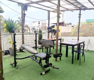 a patio with a table and exercising equipment on the grass at Casa Turística Monumental in Lima