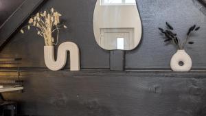a mirror on a wall with two vases and a mirror at Loft Bohème - 3 personnes in Saint-Julien-les-Villas +20 photos