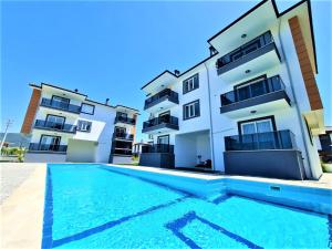 un immeuble d'appartements avec une piscine devant dans l'établissement Very hygienic apartment close to the center and the airport, à Dalaman 4 autres photos