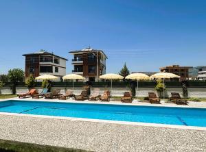 une piscine avec chaises et parasols dans l'établissement Very hygienic apartment close to the center and the airport, à Dalaman