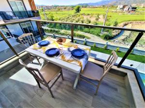 une table à manger et des chaises sur le balcon d'une maison dans l'établissement Very hygienic apartment close to the center and the airport, à Dalaman