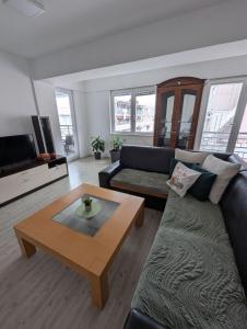 a living room with a couch and a coffee table at Lihnidos Home, Central Apartment, AC, Lake Access, Beach in Ohrid