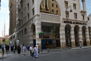 a group of people walking down a street in front of a building at منازل الصافية in Al Madinah