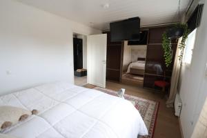 a bedroom with a white bed and a television at Luxury Apartment in the Heart of Pello in Pello