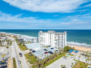 - une vue aérienne sur un bâtiment et la plage dans l'établissement New listing! Direct oceanfront condo with private balcony overlooking the pool and beach, à Ormond-by-the-Sea