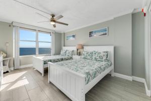 une chambre avec un lit et une fenêtre avec l'océan dans l'établissement New listing! Direct oceanfront condo with private balcony overlooking the pool and beach, à Ormond-by-the-Sea