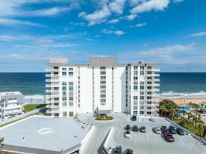 Ormond-by-the-SeaにあるNew listing! Direct oceanfront condo with private balcony overlooking the pool and beachの駐車場付きのビーチ沿いのアパート