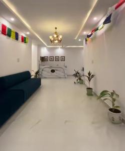 a living room with a blue couch and plants at Hotel Dream Inn Khajuraho in Khajurāho