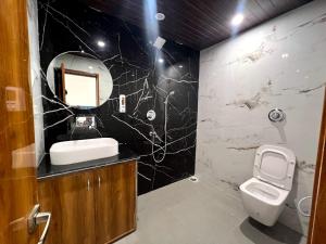 a bathroom with a toilet and a sink and a mirror at Hotel Dream Inn Khajuraho in Khajurāho +26 photos