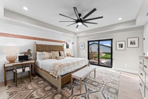 a bedroom with a bed and a desk and a ceiling fan at Keenan Beach w/Beach, Heated Pool & Game Room in Mooresville +102 photos