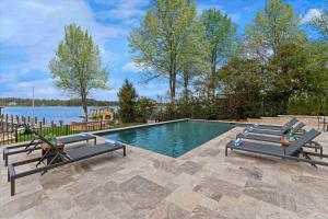 a swimming pool with two benches and the water at Keenan Beach w/Beach, Heated Pool & Game Room in Mooresville