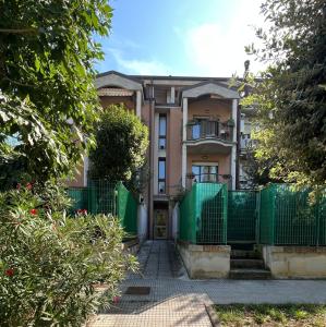 a house with a green fence in front of it at La casetta di Nonno Carlo a due passi dall'ospedale in Torrette