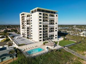 an aerial view of a large white building at Renovated direct oceanfront condo with spacious balcony, heated pool, and garage parking in Ormond-by-the-Sea