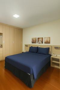 - une chambre avec un grand lit bleu dans l'établissement BOOK A FLAT Jardim Paulista em Hotel, à São Paulo
