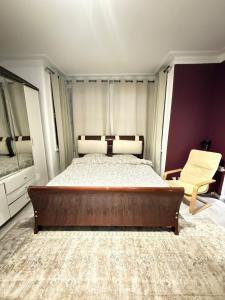 a bedroom with a large bed and a chair at Cozy Flat near Harrow-on-the-Hill Station in Harrow