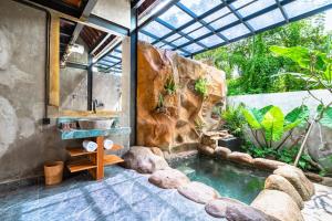 a bathroom with a sink and a waterfall at Weda Ubud by Madhava Villas in Ubud