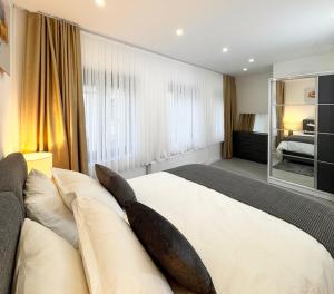 Le Chic 102 في بروكسل: غرفة نوم بها سرير كبير مع وسائد على الأريكة