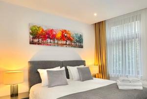 a bedroom with a bed and a painting on the wall at Le Chic 102 in Brussels