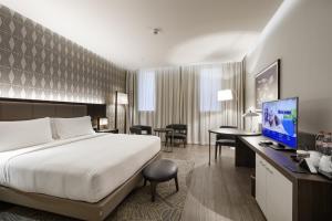 a hotel room with a bed and a desk with a computer at Doubletree By Hilton Pointe-Noire City Centre in Pointe-Noire