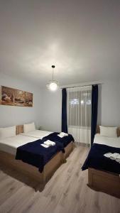 une chambre avec deux lits et une fenêtre dans l'établissement Royal Galaxy, à Kazbegi