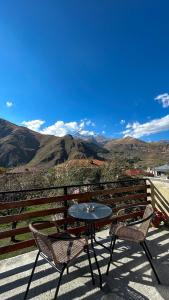 d'une table et de deux chaises sur un balcon avec vue sur les montagnes. dans l'établissement Royal Galaxy, à Kazbegi