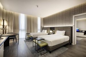 a hotel room with two beds and a desk at Doubletree By Hilton Pointe-Noire City Centre in Pointe-Noire +23 photos