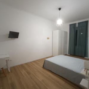 a white bedroom with a bed and a desk at B&B Il Palazzo in Bassano Romano