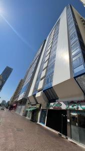 a tall building on a street in front of a building at XD Hostel Apartments in Abu Dhabi