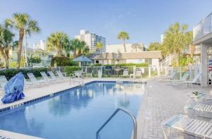 una gran piscina con sillas en Cozy island apartment, en Pompano Beach
