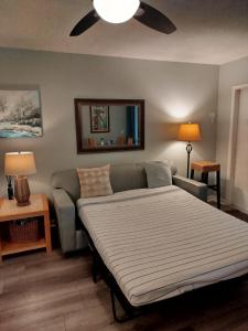 1 dormitorio con cama, sofá y ventilador de techo en Cozy island apartment, en Pompano Beach 27 fotos más