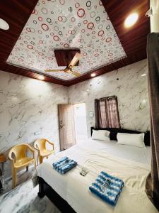 a bedroom with a large white bed with a stone wall at Manjunath Homestay in Hampi