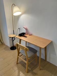 a wooden table with a chair and a lamp at ITCC Manhattan Suites by Cozyqa Stay in Donggongon +2 photos