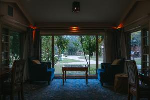 欧奈宰Muzdan Holiday homes的客厅配有椅子和桌子,设有大窗户