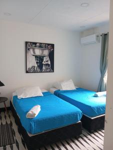 two beds with blue sheets in a room at 12 Céntrico y Confortable apto Casa Doña Yola in Cartagena de Indias