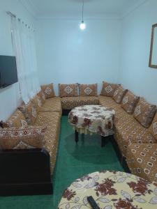 a living room with a couch and a table at Casa maartil in Martil +1 photo